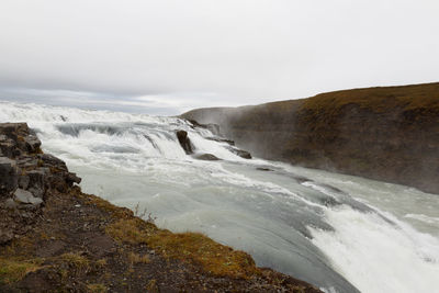 Scenic view of waterfall against sky