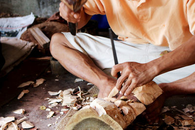 Low section of man carving in workshop
