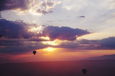 Silhouette hot air balloon against sky during sunset