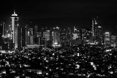 Illuminated buildings in city against sky at night