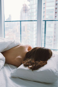 High angle view of woman sleeping on bed