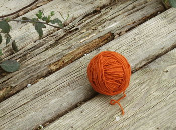 High angle view of orange wool ball on wooden table