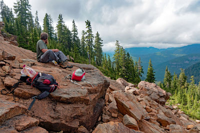 People sitting on mountain against sky