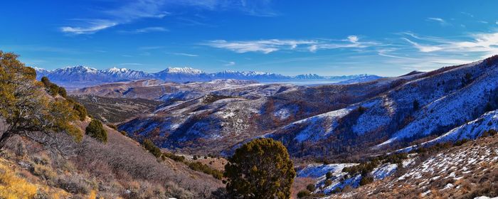 Scenic view of snowcapped mountains against blue sky