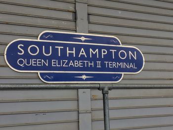 Low angle view of road sign against blue sky