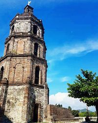 Low angle view of tower against blue sky