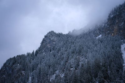 Low angle view of snow covered mountain against sky