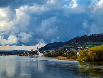 Scenic view of river by mountains against sky