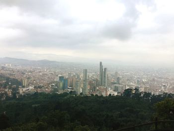 Aerial view of buildings in city against sky