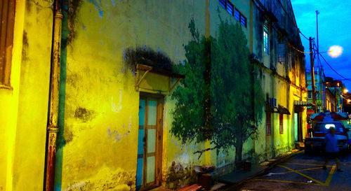 Yellow abandoned building by street at night