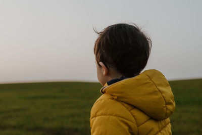 Child with yellow hooded jacket