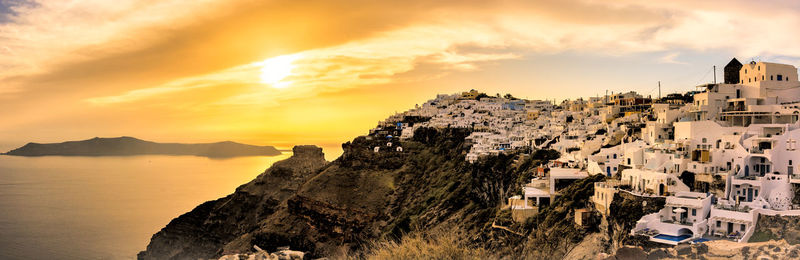 High angle view of townscape by sea against sky during sunset