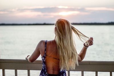 Rear view of woman looking at sea against sky