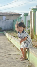 Full length of girl standing on footpath