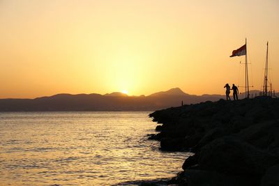 Couple on coastline at sunset