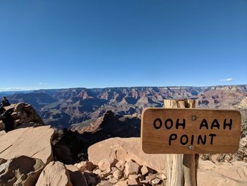 Information sign on mountain against clear blue sky during sunny day