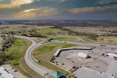 High angle view of road amidst field against sky