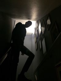 Silhouette man standing in dark room