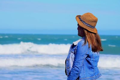 Side view of mid adult woman standing at beach