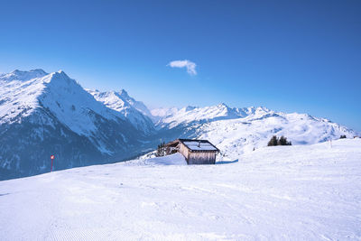 Log cabin on snow covered mountain during winter