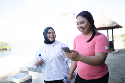 Portrait of smiling couple standing against clear sky