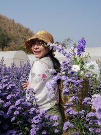 Portrait of smiling woman with purple flowering plants