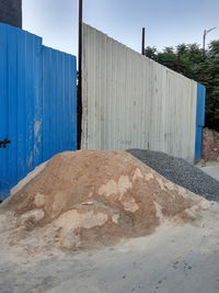 View of wall and fence against sky