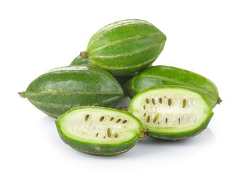 Close-up of green fruits against white background