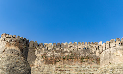 Low angle view of old ruins against clear blue sky