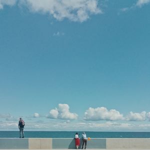 People standing at beach against sky