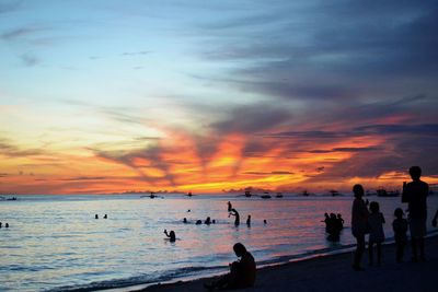People on beach at sunset
