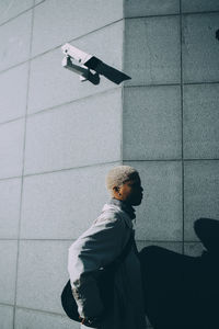 Young woman standing against wall