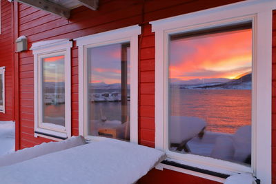 Sea seen through window during sunset