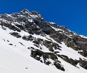 Scenic view of snow covered mountains against clear blue sky