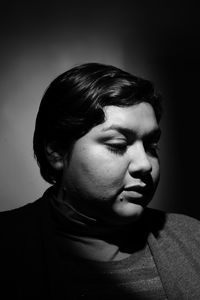 Close-up portrait of young man against black background