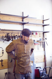 Male craftsperson wearing protective workwear at wood shop