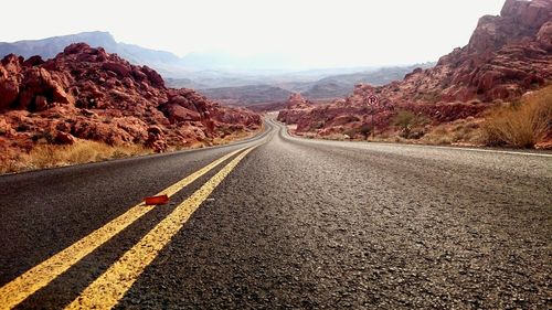 Empty road leading towards mountains