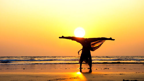 Silhouette man on beach against sky during sunset