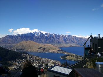 Scenic view of sea and mountains against blue sky