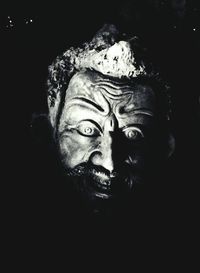 Portrait of young man against black background
