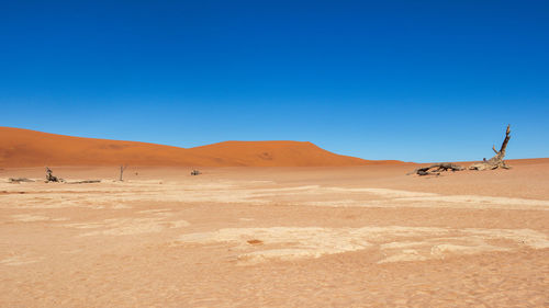 Scenic view of desert against clear blue sky