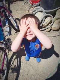 High angle view of boy covered with bicycle