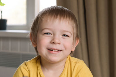 Child boy with blonde hair baby looking at camera. portrait 3 years old kid. boy toddler at home. 