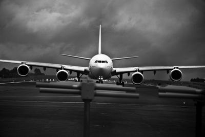 Low angle view of airplane at airport runway against sky