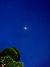 Low angle view of moon against clear blue sky