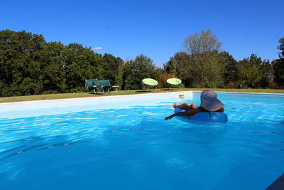 Woman using inflatable ring in swimming pool 