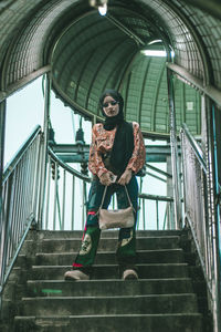 Low angle portrait of girl standing on staircase