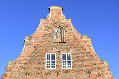 Low angle view of bell tower against blue sky