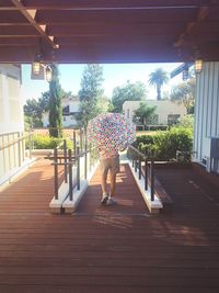 Rear view of woman standing by swimming pool