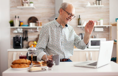 Midsection of man using smart phone on table